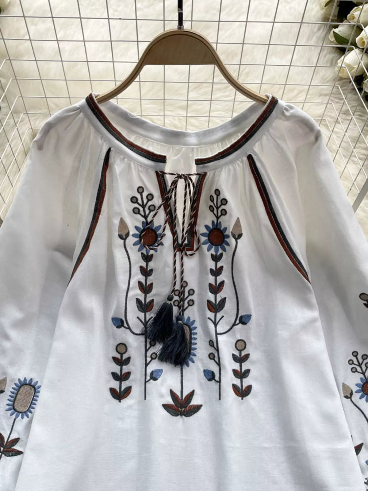 Embroidered blouse laid flat, full garment view