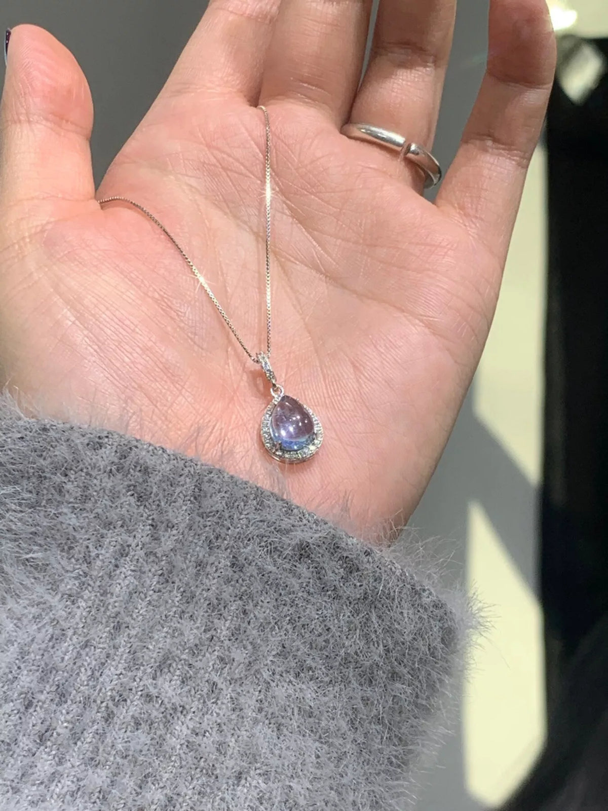 Crystal teardrop pendant sterling silver necklace, close up fabric detail