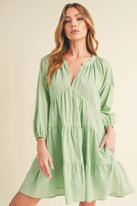 Light green notched balloon sleeve tiered mini dress front view on model