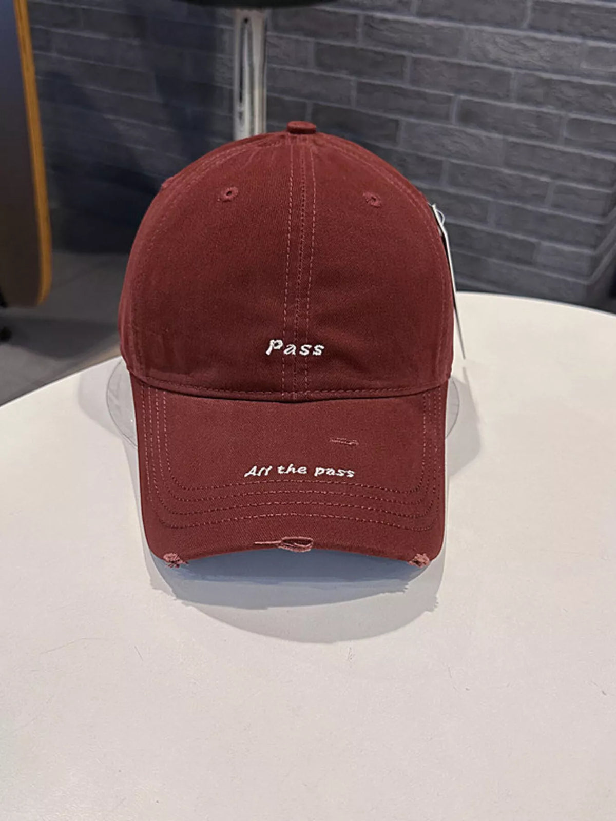 Distressed baseball cap with embroidered slogan brim view
