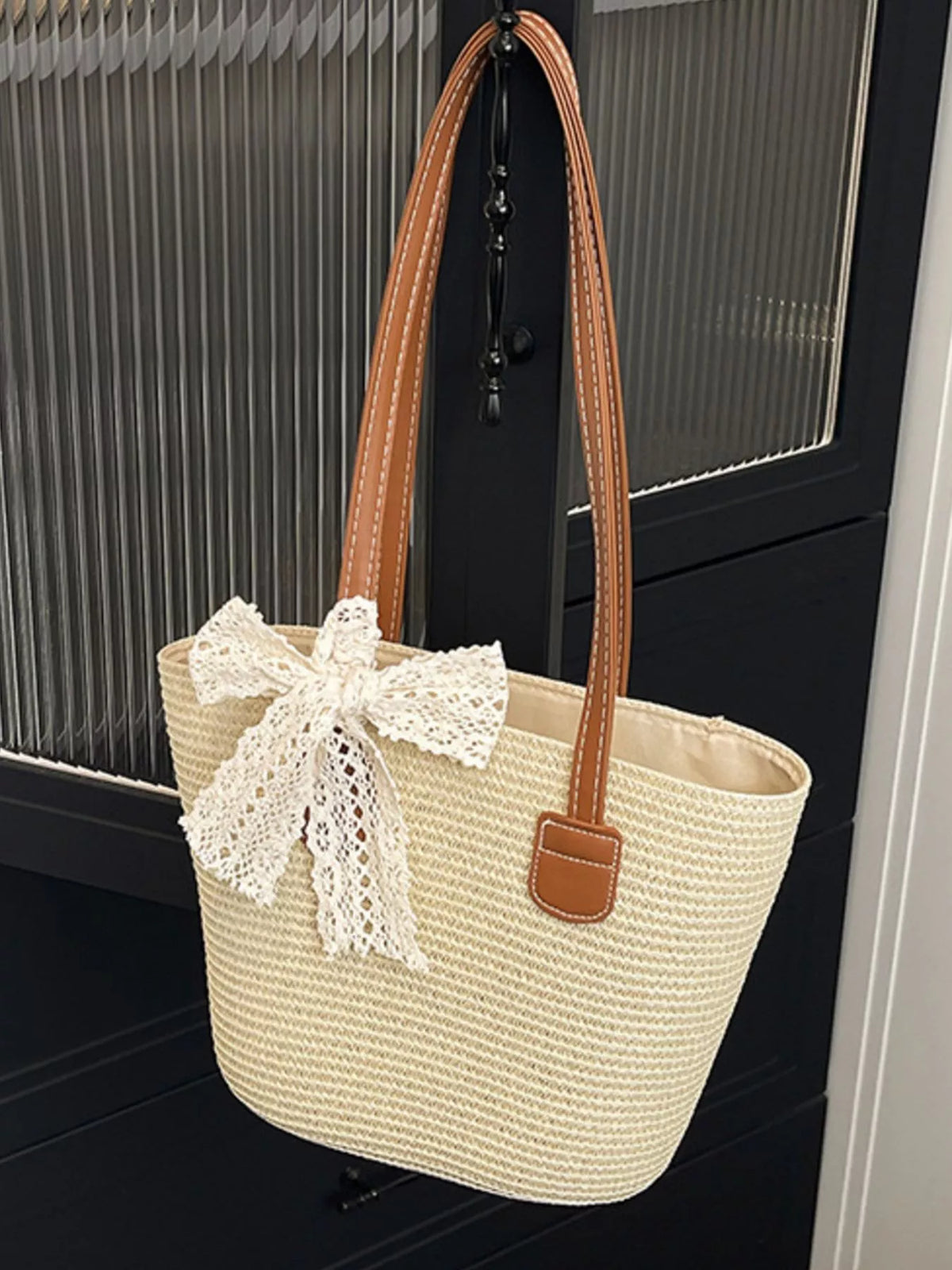 Model carrying woven straw shoulder bag