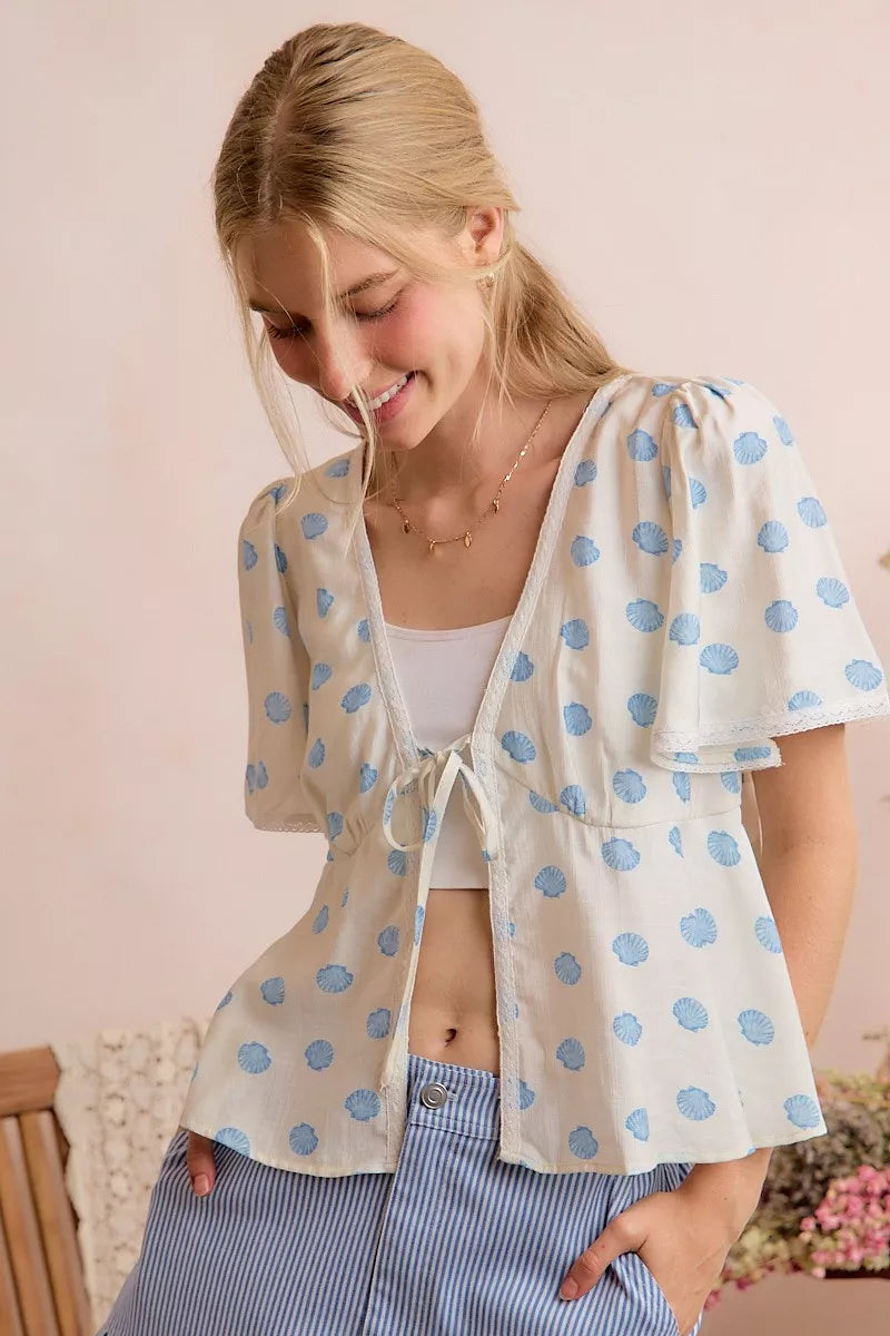 Ivory and blue shell print tie front flutter sleeve blouse back view