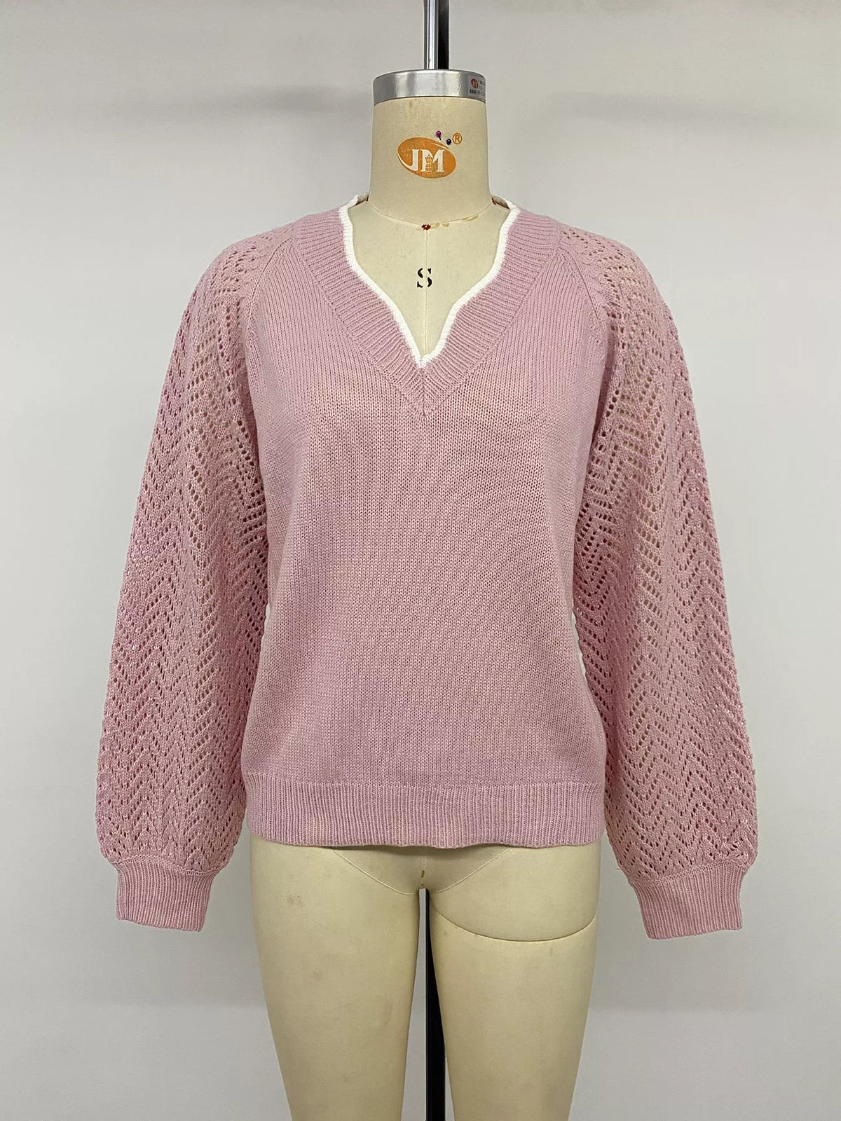 Openwork knit texture and drape of the pink sweater