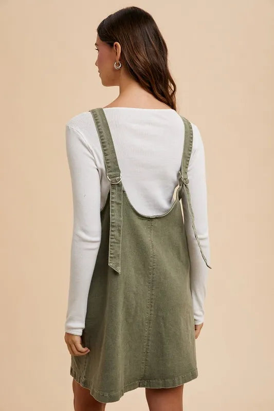 Denim pinafore dress side view with pockets