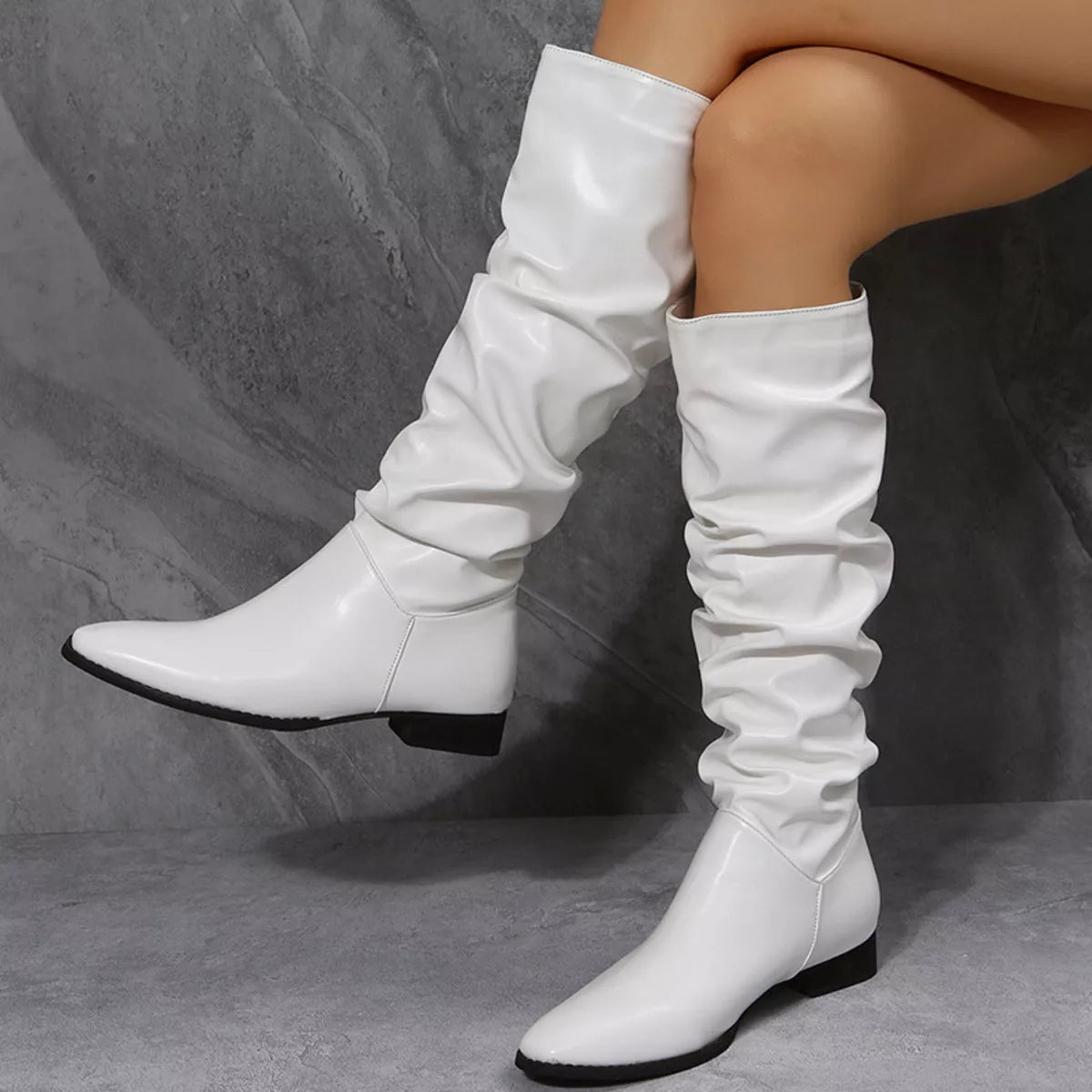 White slouchy block heel boots styled on model