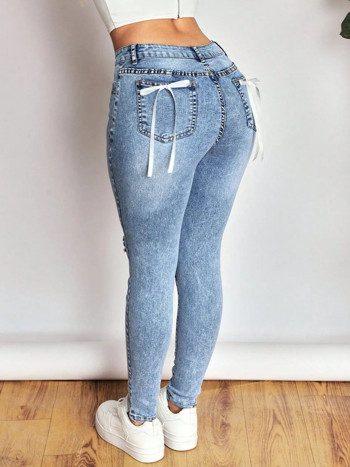 Bow back skinny jeans distressed detail