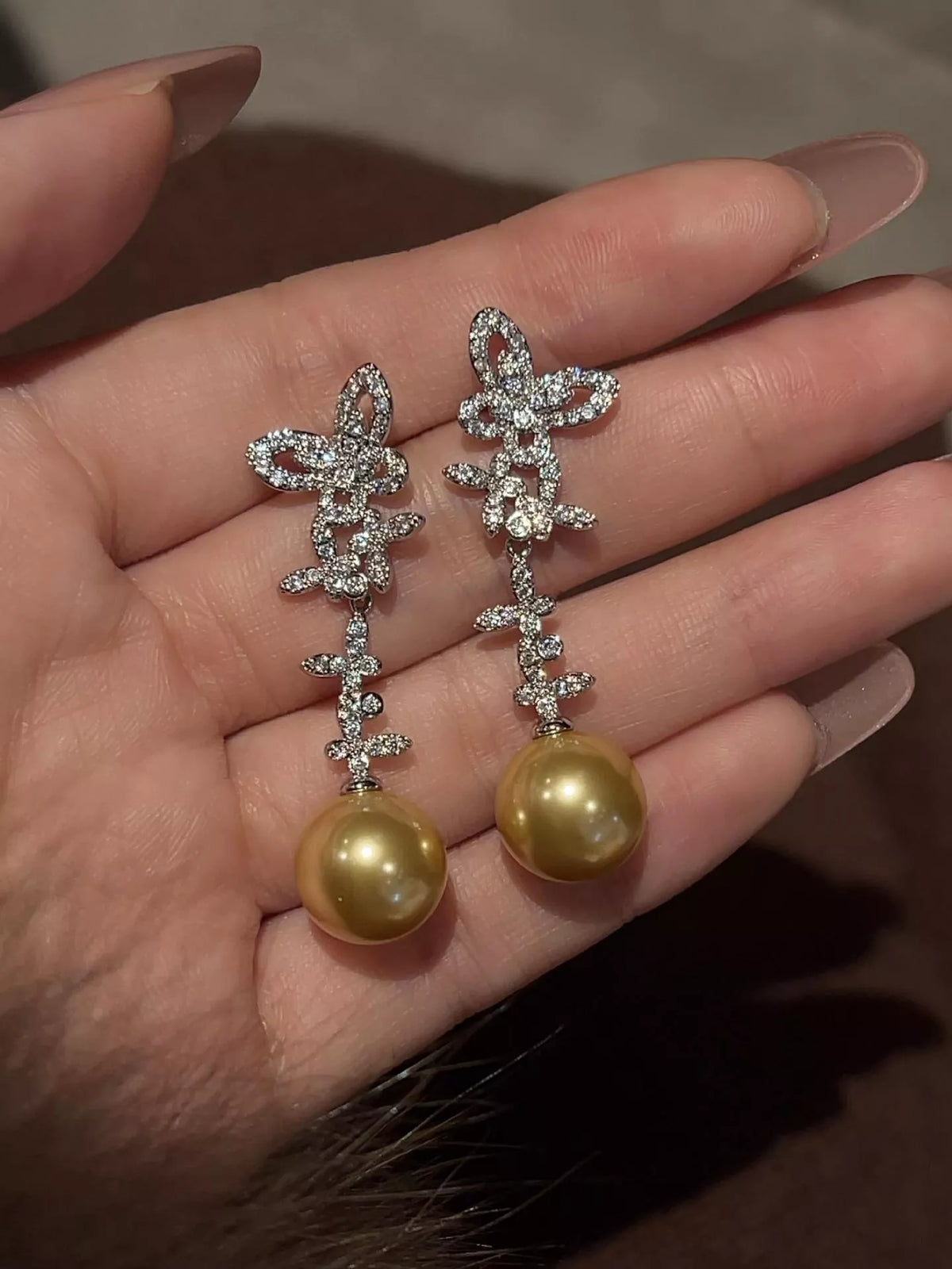 Butterfly pearl drop earrings pair on display