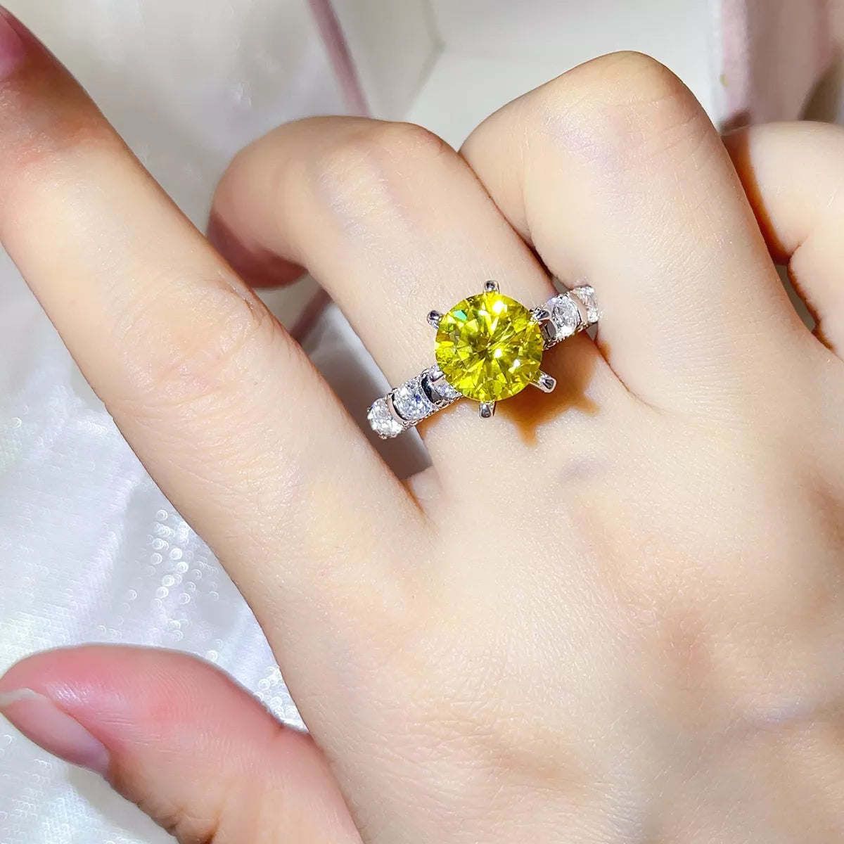 Close view of the round brilliant yellow moissanite centre stone and shoulder accents