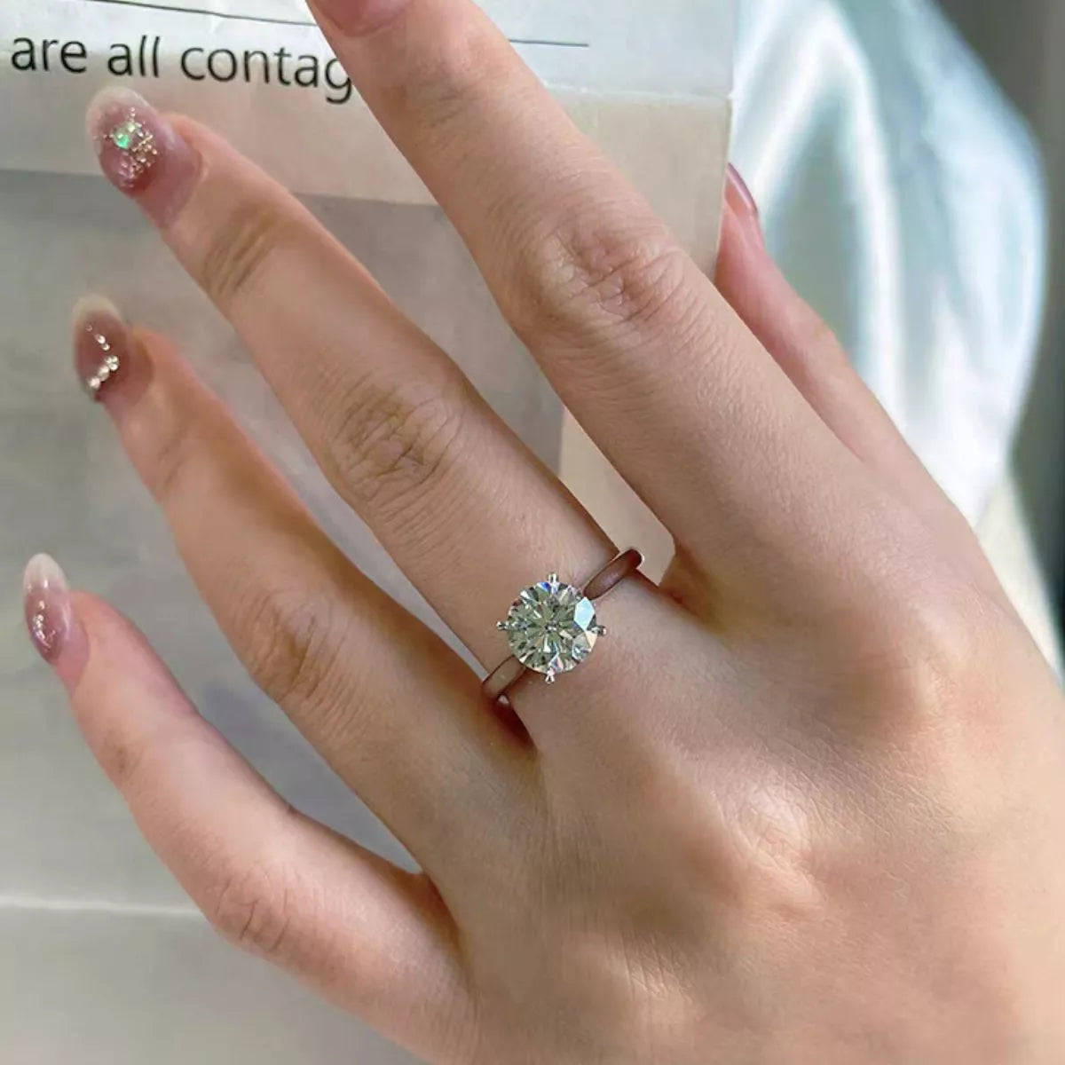 Moissanite sterling silver ring shown on a hand
