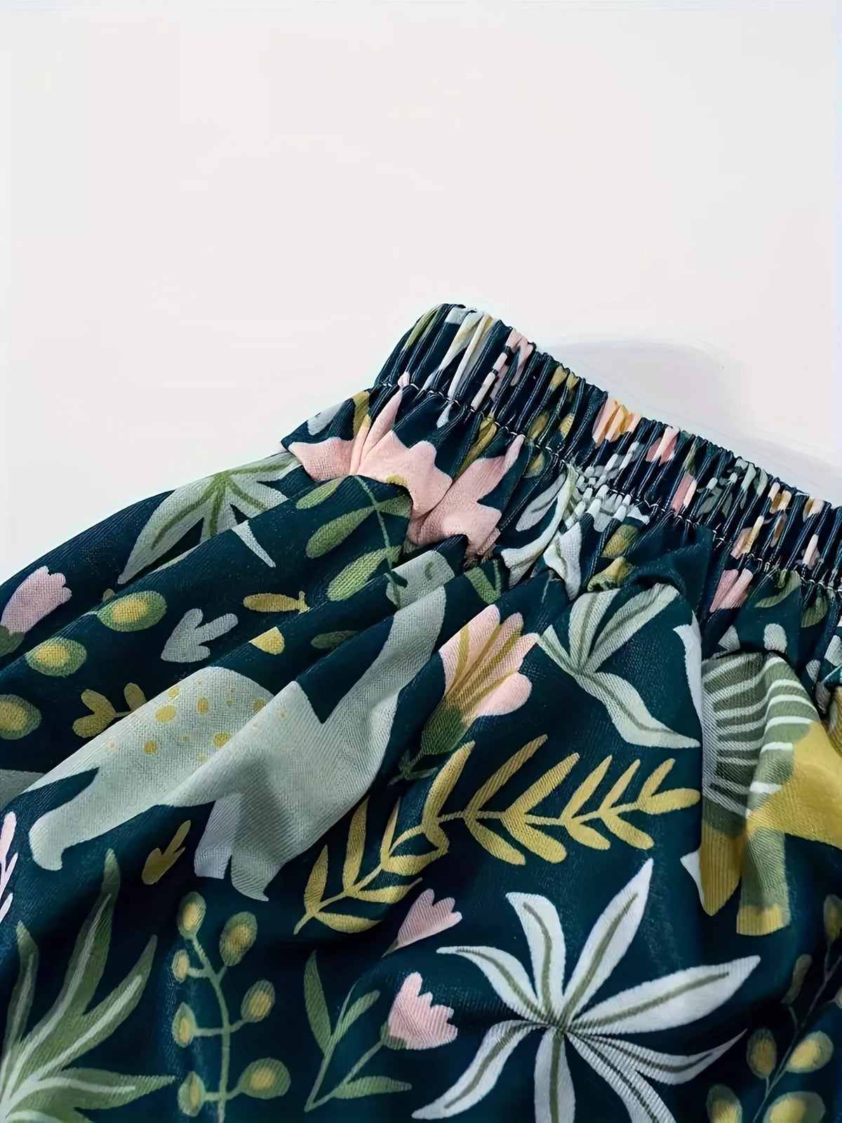 Close view of the dinosaur and botanical print on the skirt fabric