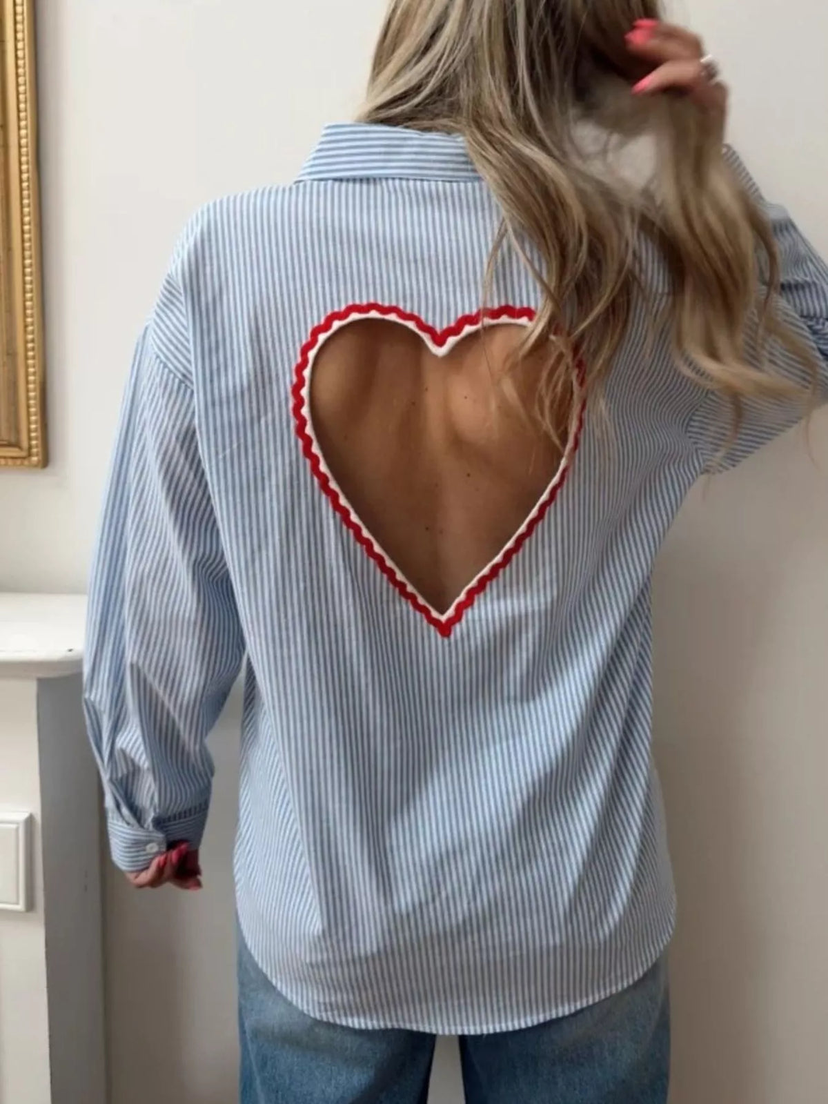 Close view of the cutout and button placket on the blue striped shirt