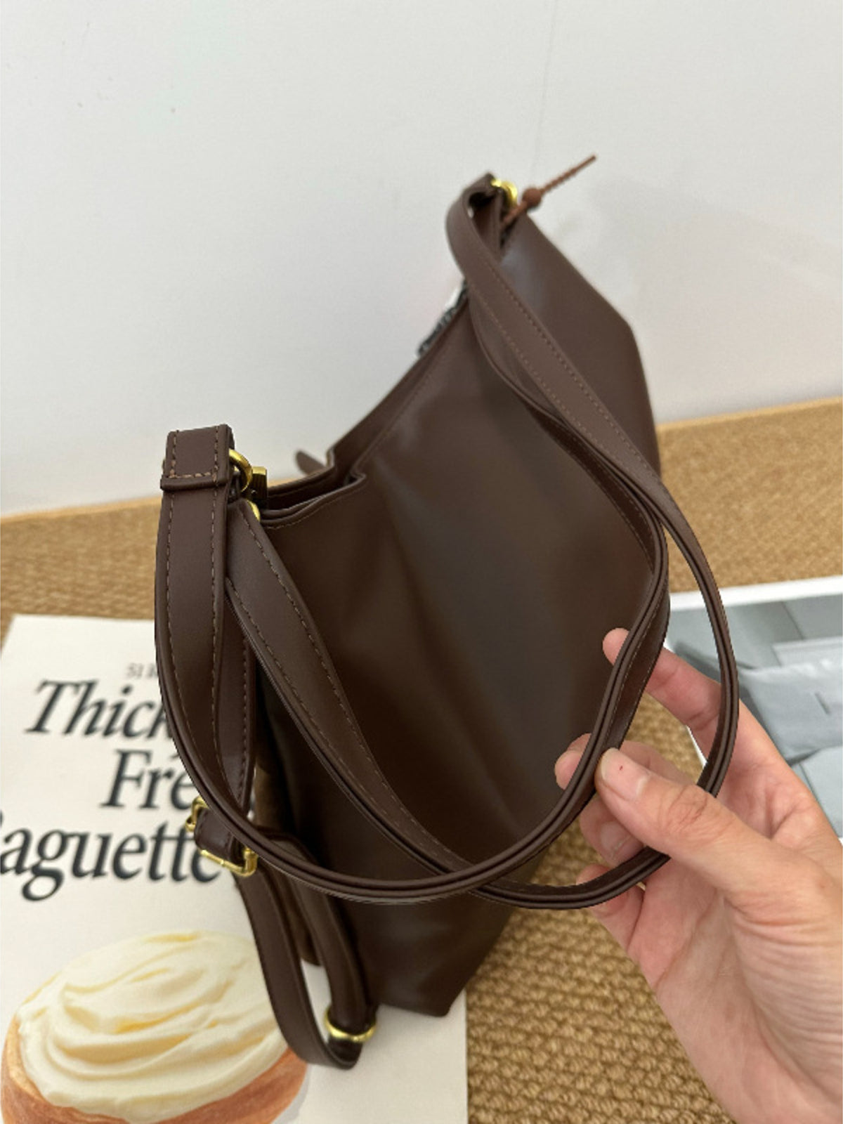 Model carrying brown nylon shoulder bag