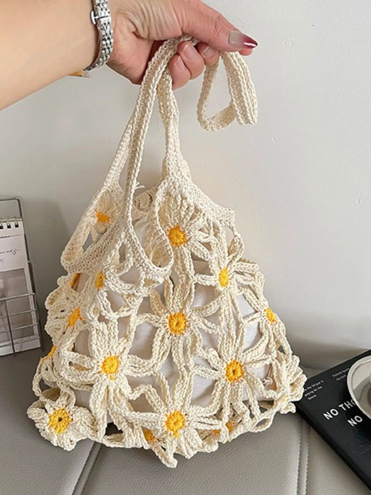 Model carrying daisy crochet shoulder bag