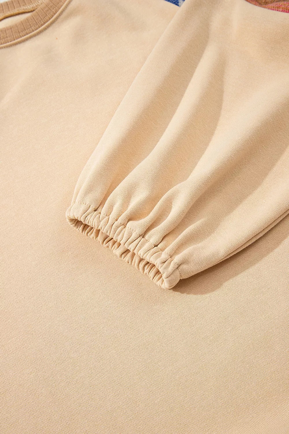 Detail of the neckline on the tan western sweatshirt