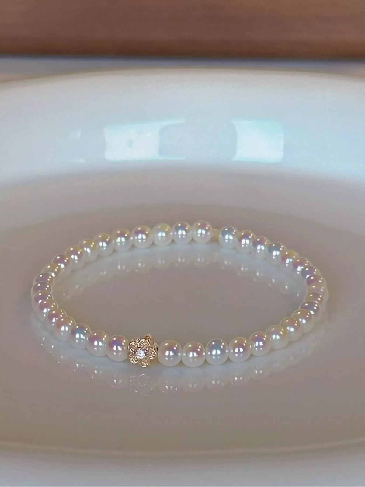 White pearl bracelet with gold floral accent