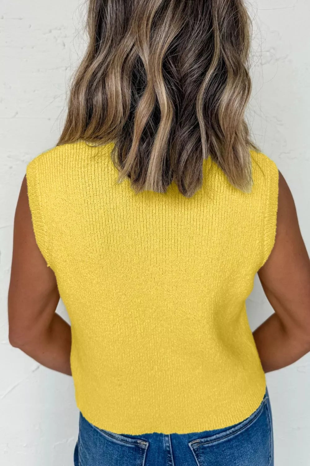 Side view of yellow sweater vest with pockets