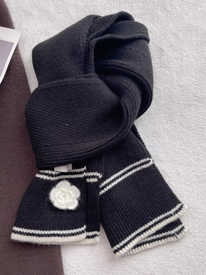 Black knitted scarf with camellia accent shown at full length