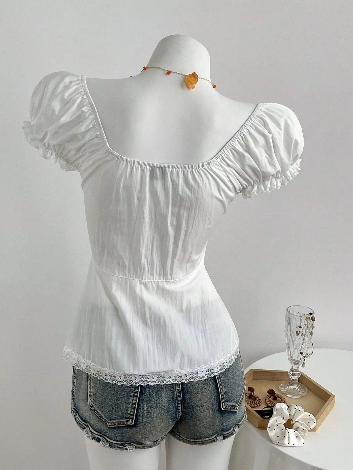 Cropped white lace shirt styled with high waisted denim