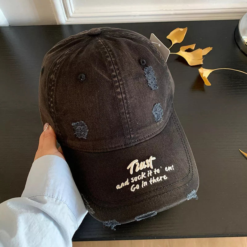 Close up of embroidery on distressed cotton cap
