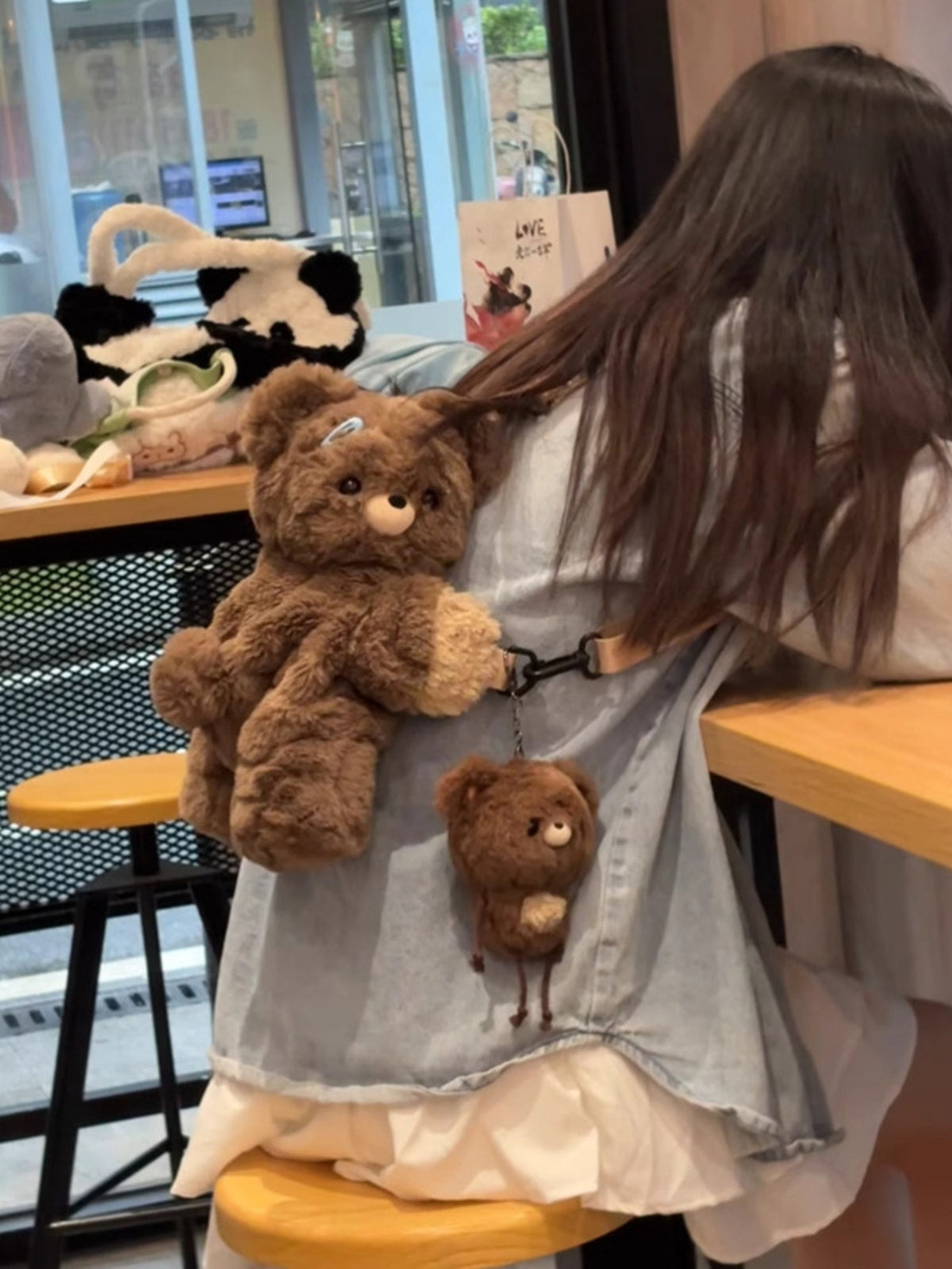 Dark brown plush teddy bear backpack zip and hardware detail