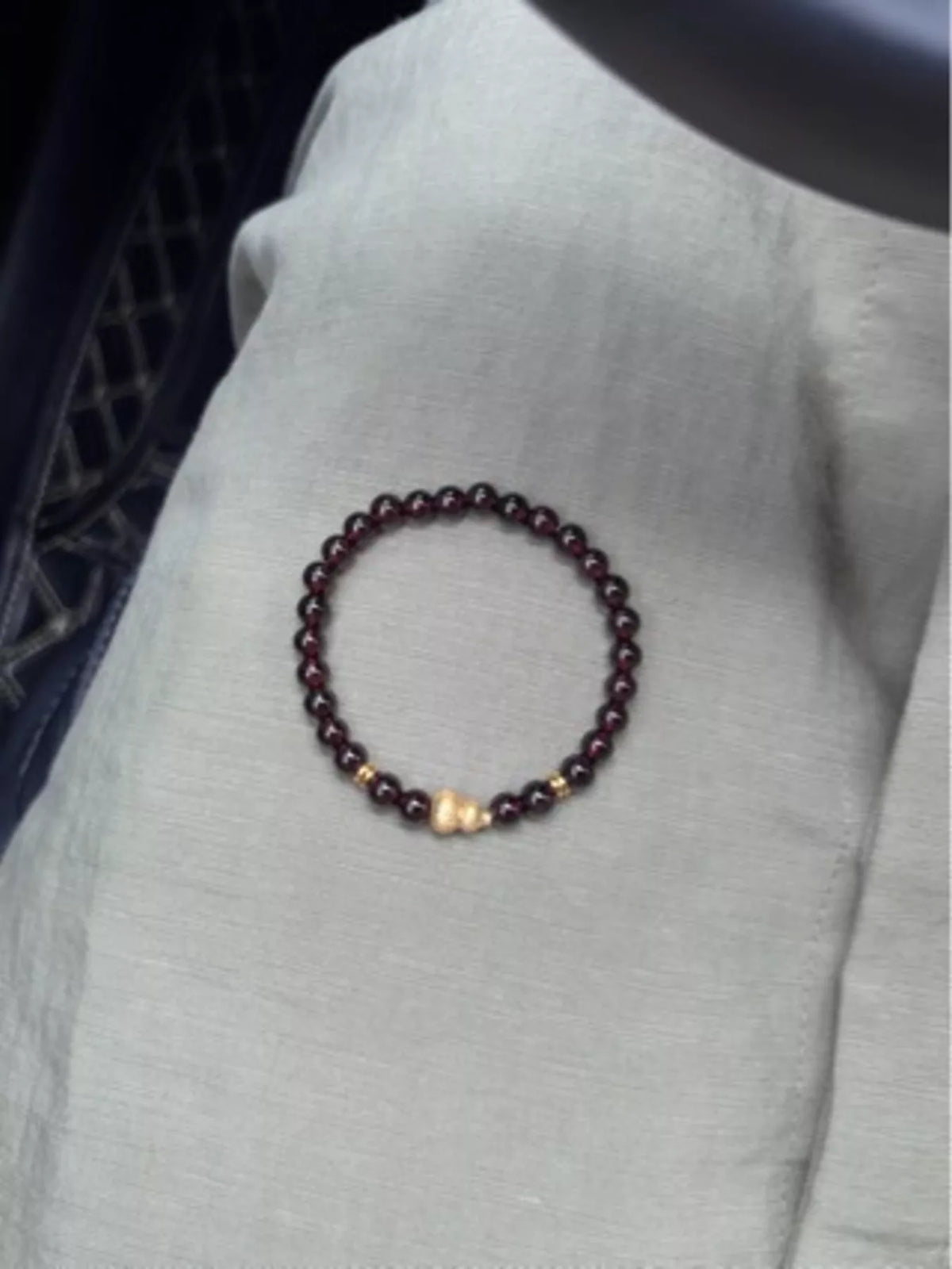 Gold toned gourd beaded bracelet coiled flat lay