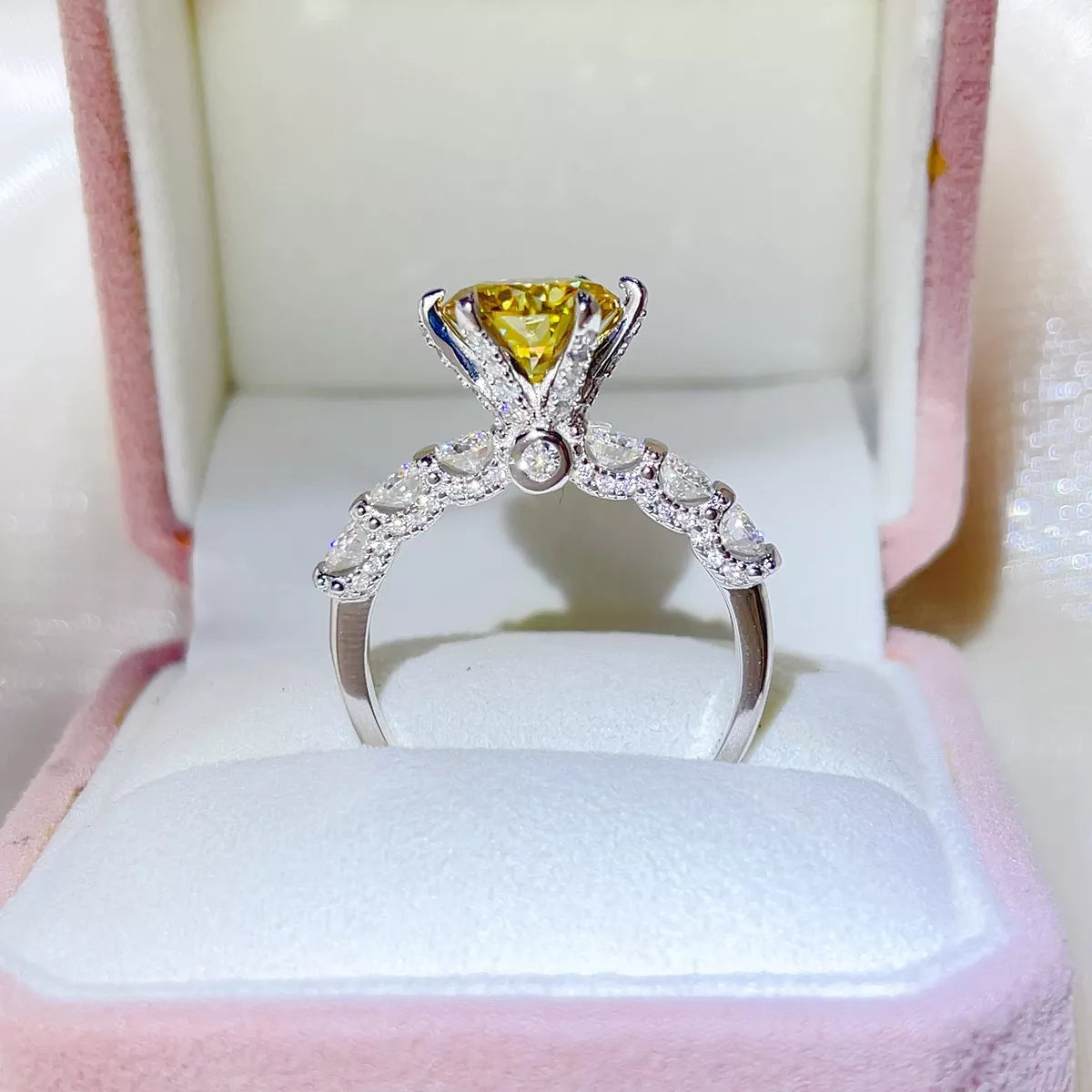 Yellow moissanite ring shown from the side to show the raised prong setting