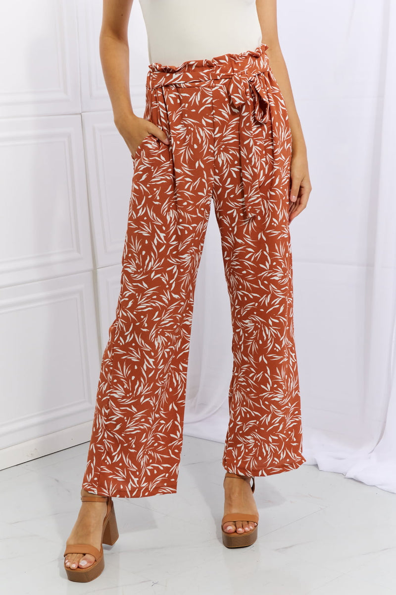 Front view of red orange geometric printed pants with paperbag waist
