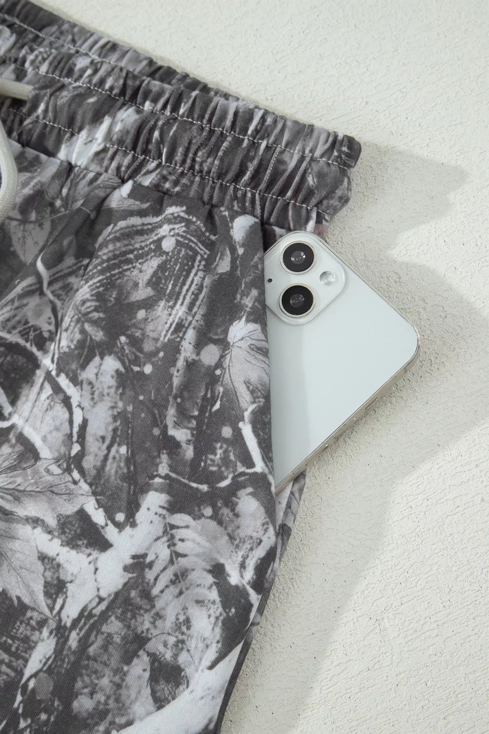 Grey abstract maple leaf print drawstring shorts full length view