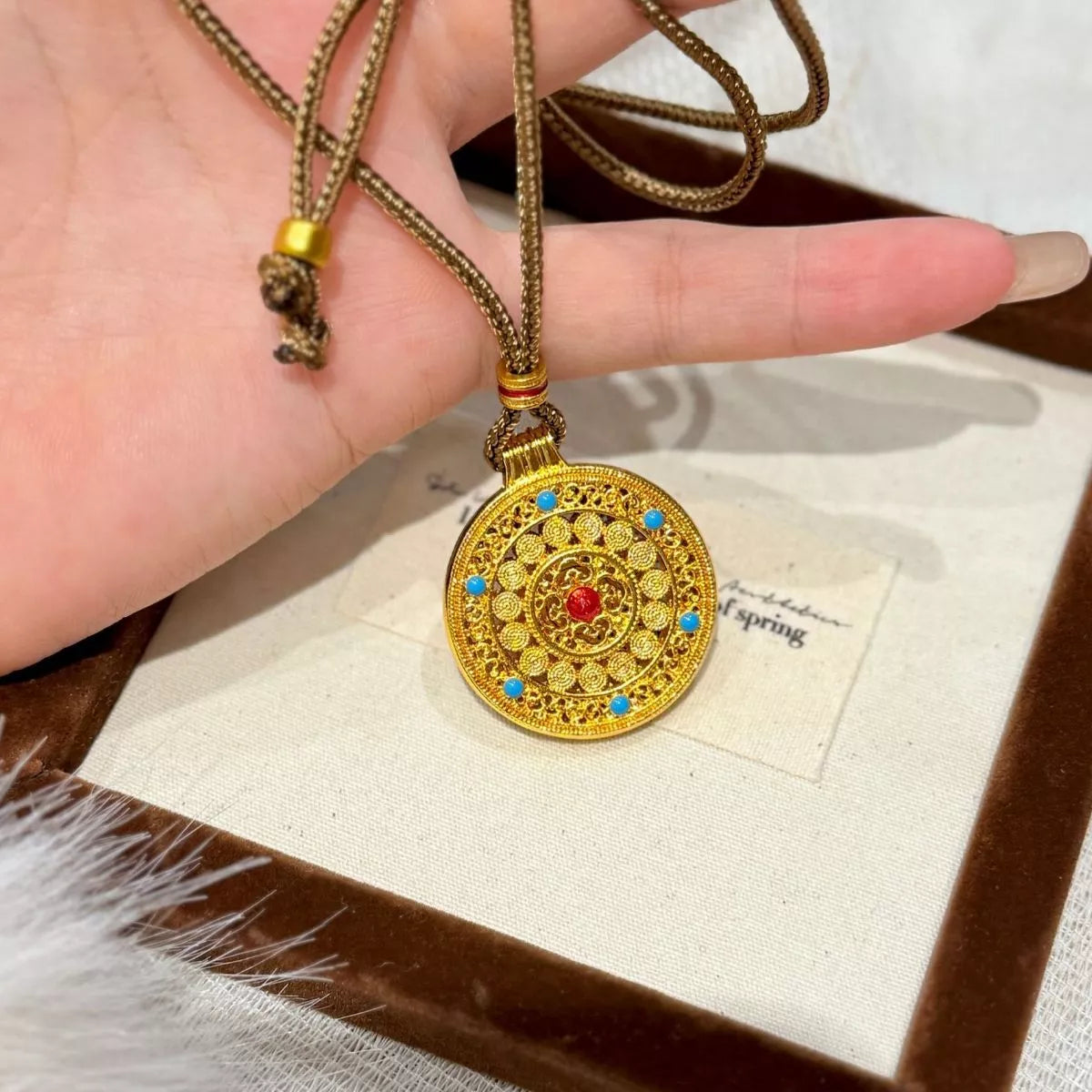 Gold round pendant necklace on neckline