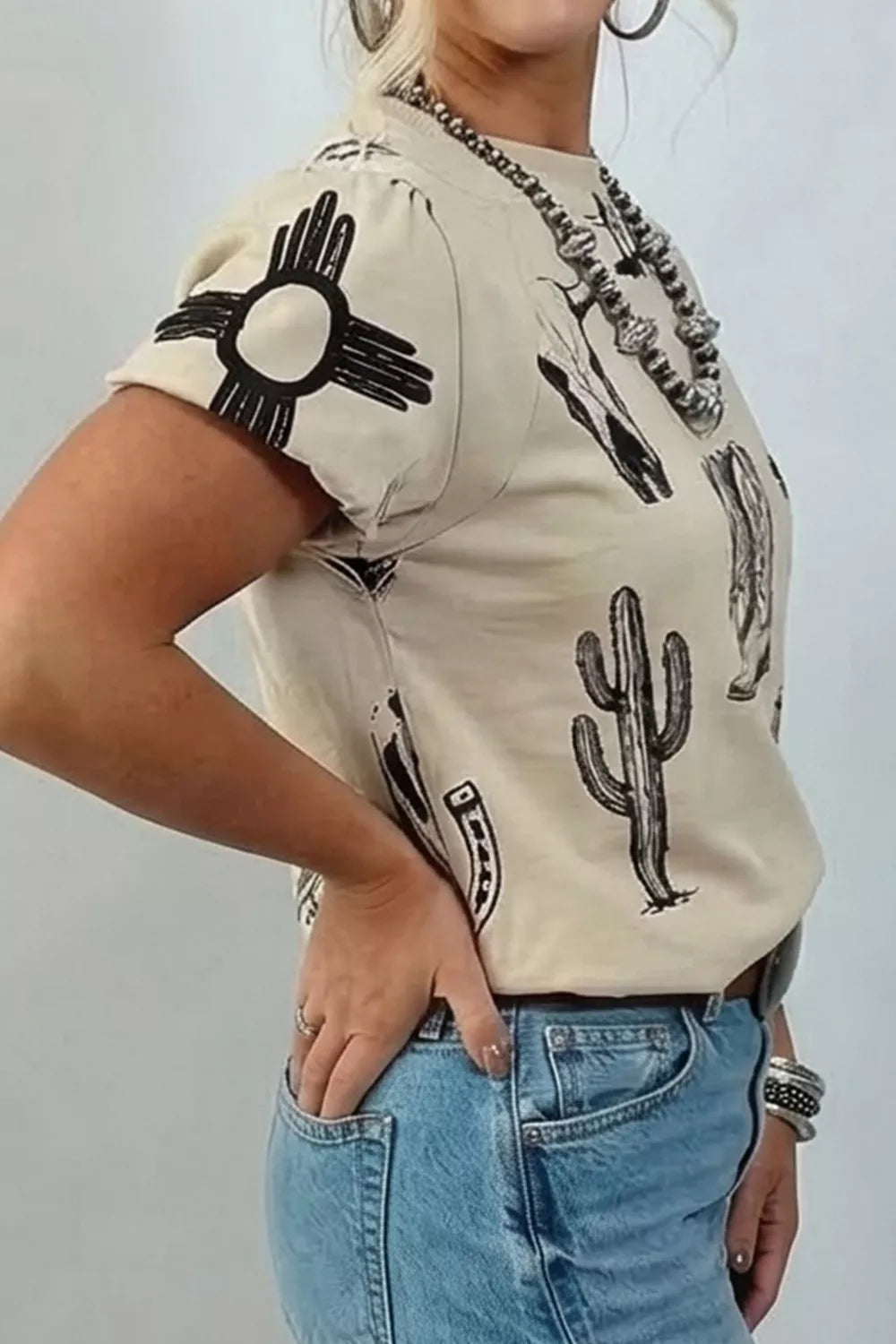 Sleeve and hem detail on a khaki western print tee