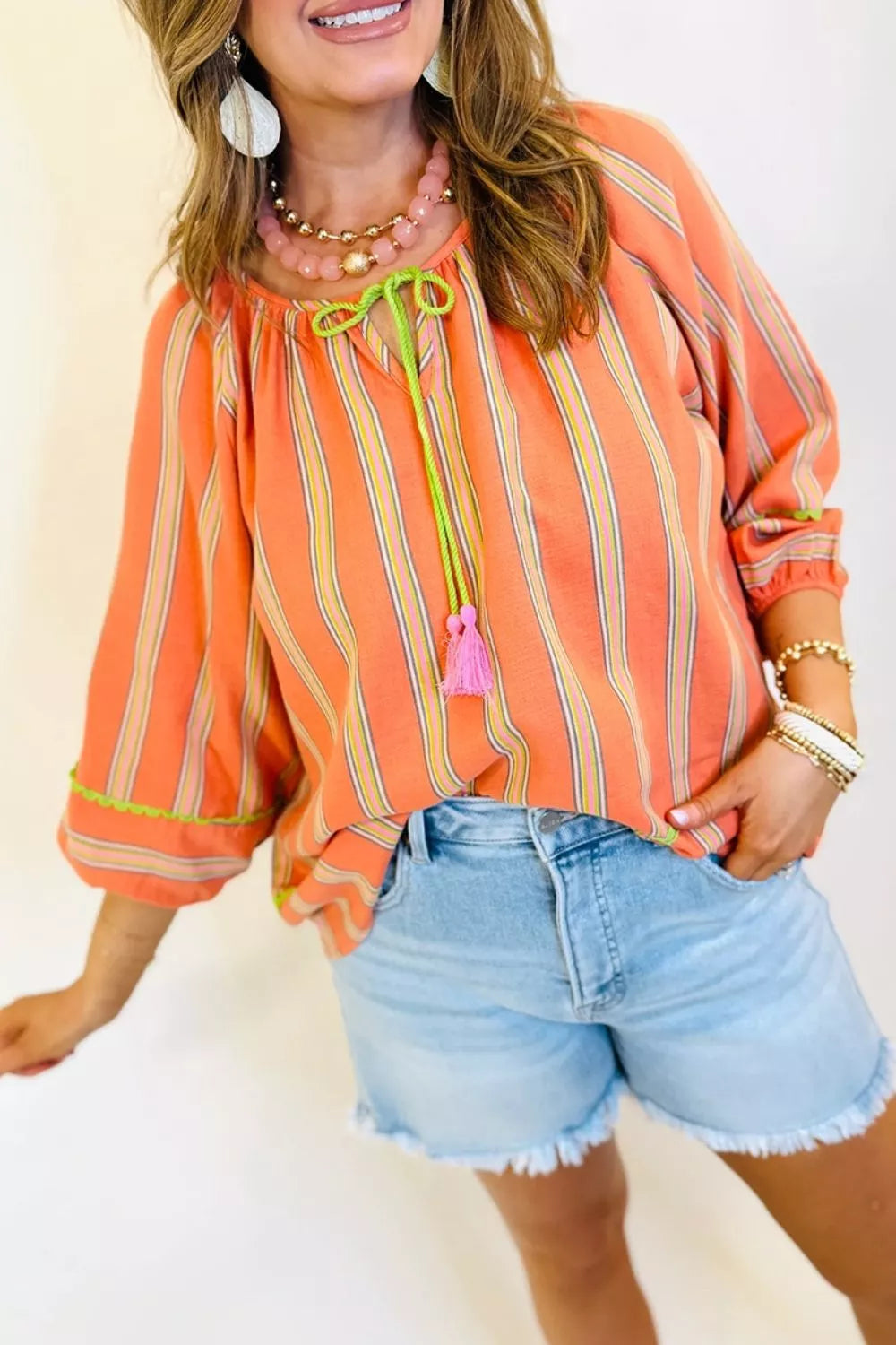 Tie neck striped blouse shown from the side on model