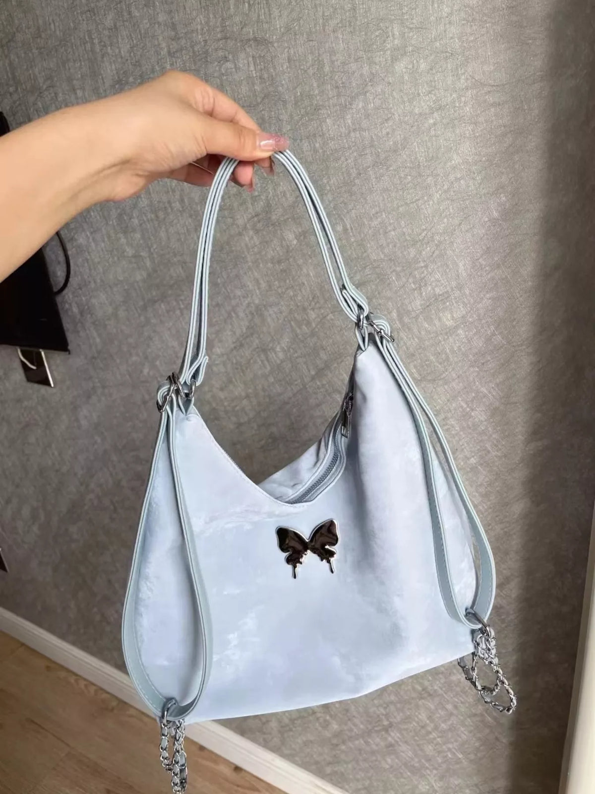 Butterfly accent convertible shoulder bag in blue front view