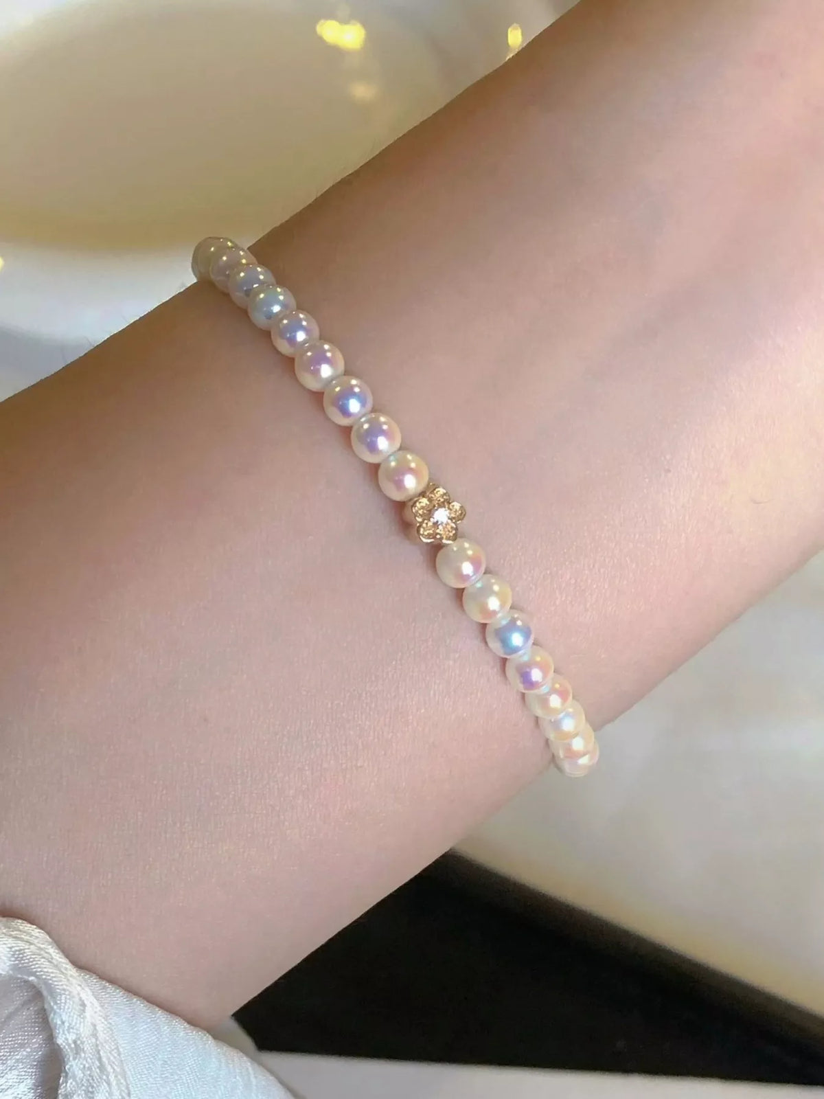 White pearl bracelet with gold floral accent