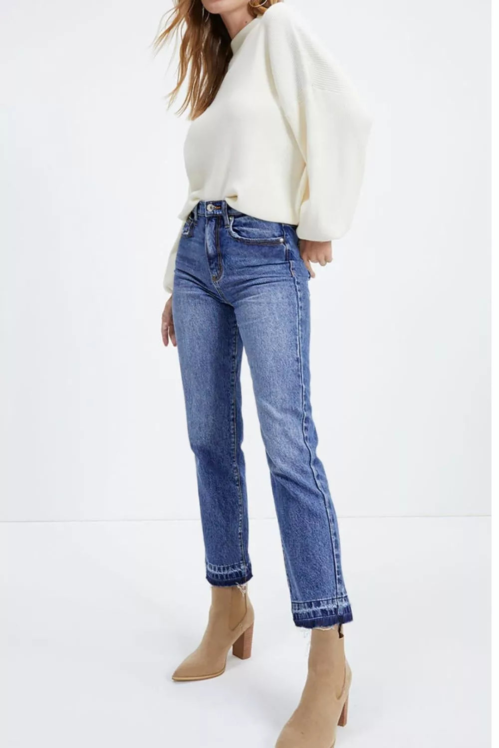 Whiskering and raw hem detail on dusty blue jeans