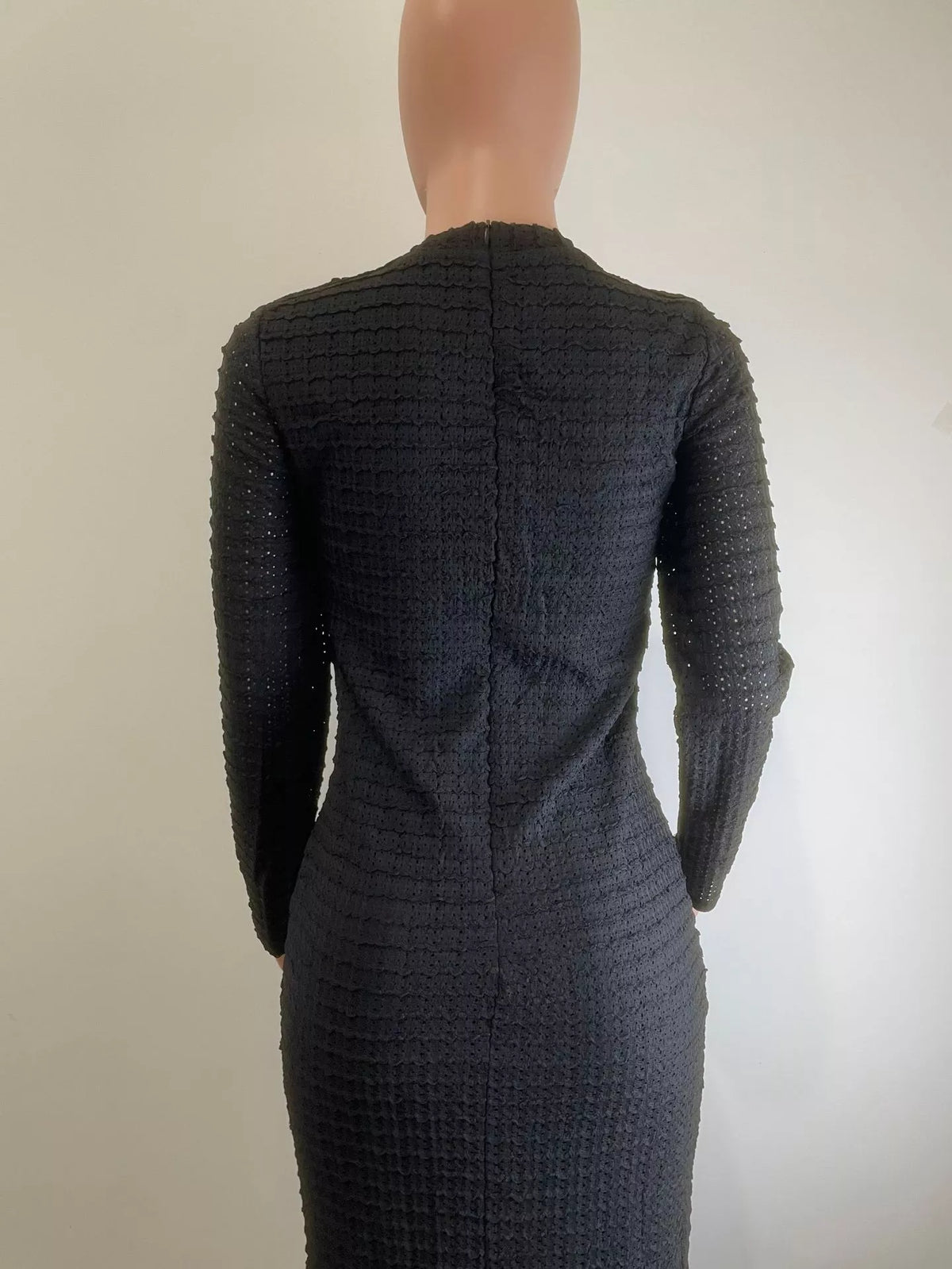 Button and zipper detail on the black textured dress