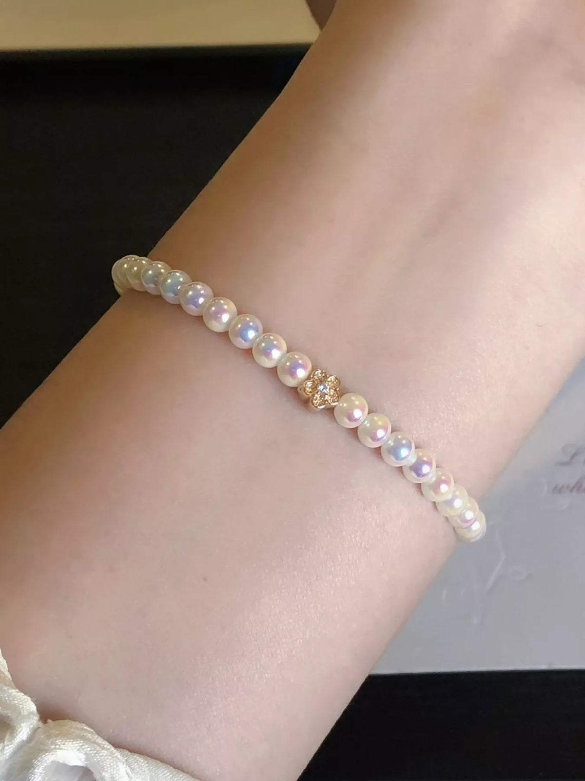White pearl bracelet with gold floral accent
