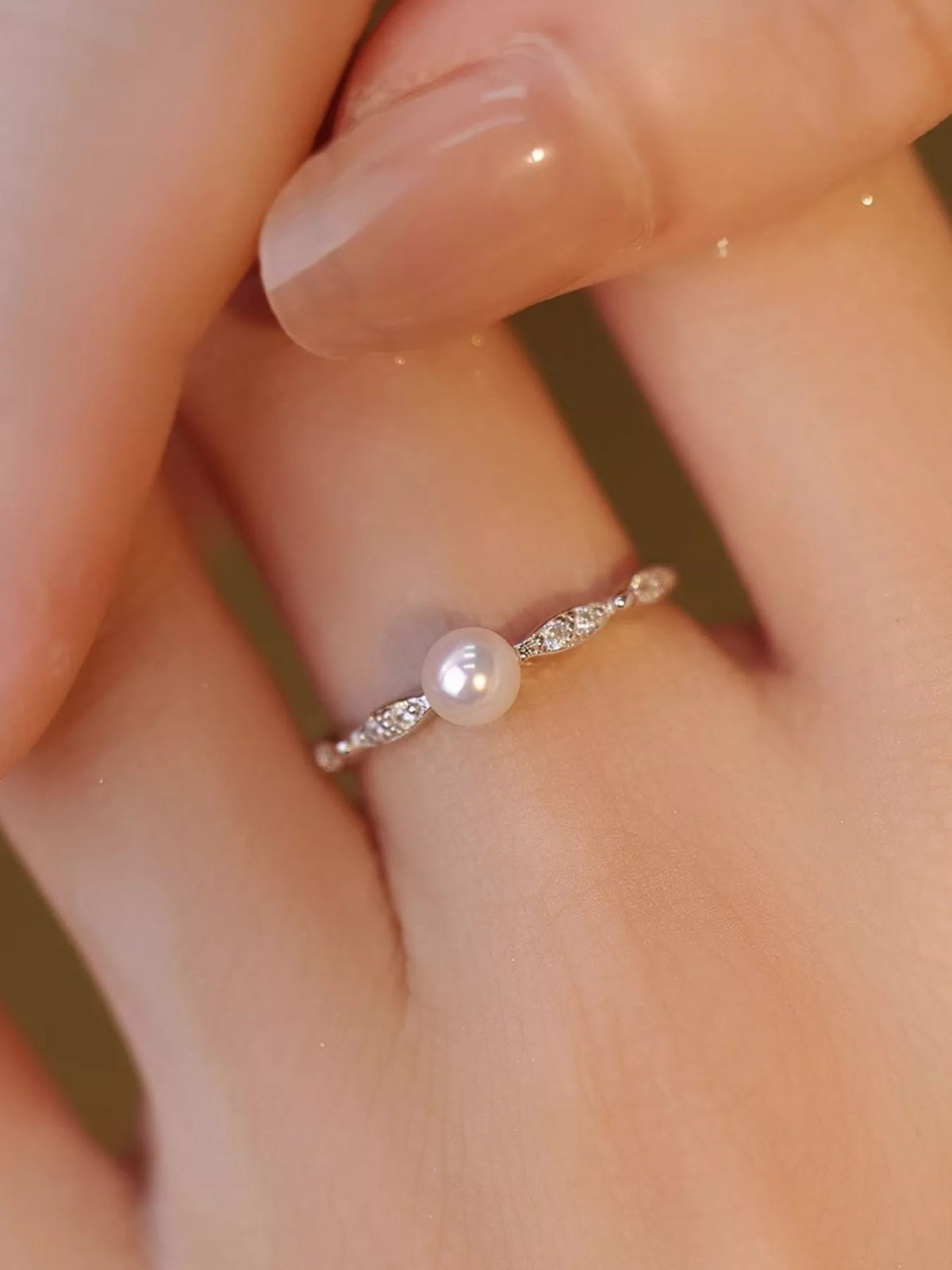 Pearl ring on finger