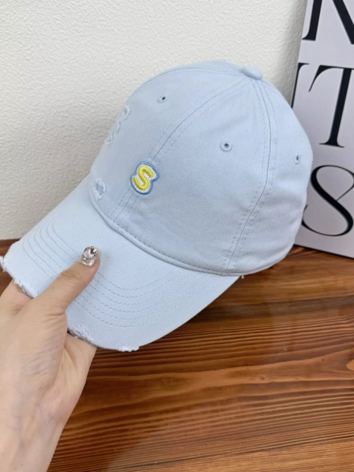 Distressed cap worn on model