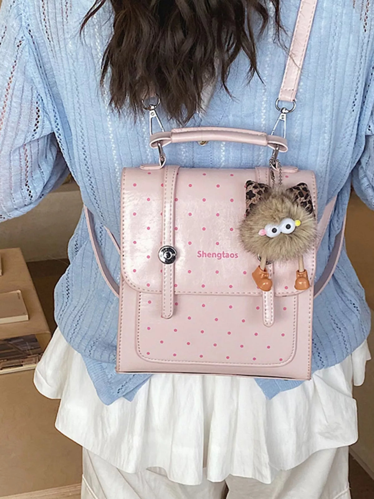 Blush pink polka dot mini backpack worn on the shoulders