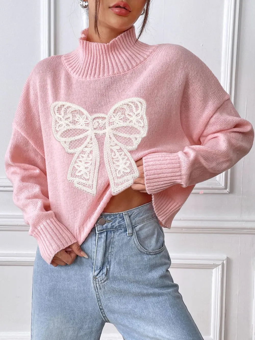 Bow turtleneck sweater in blush pink on model