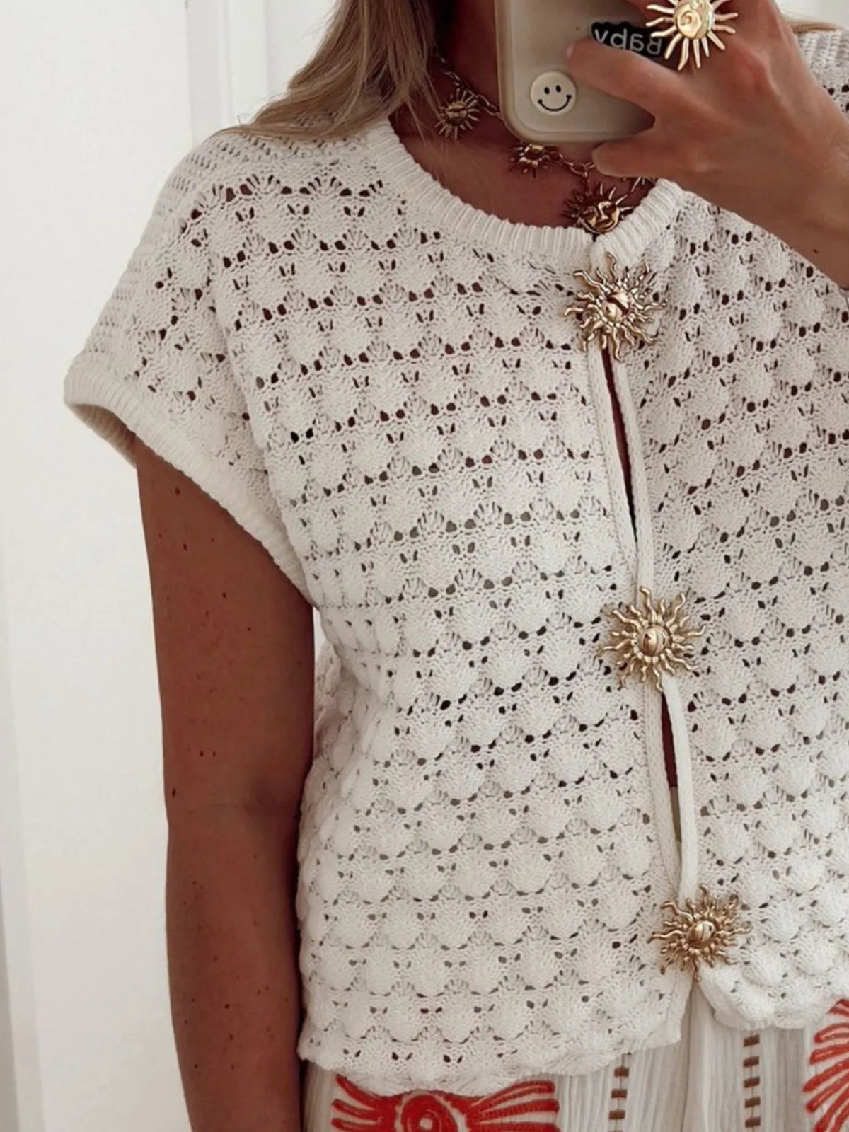 White crochet cardigan worn open over a tank
