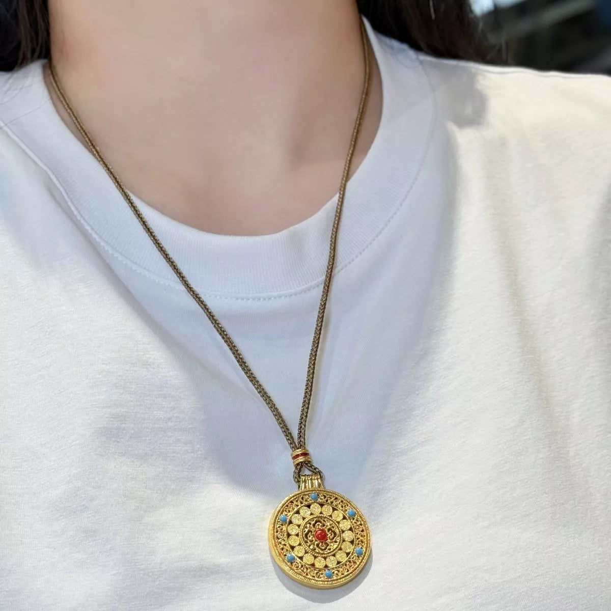 Gold round pendant necklace with zircon accents detail