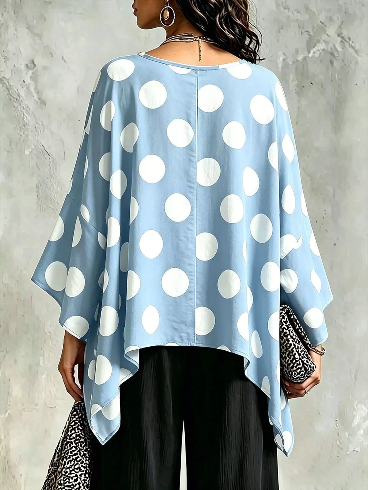 Asymmetrical hem detail on the polka dot blouse