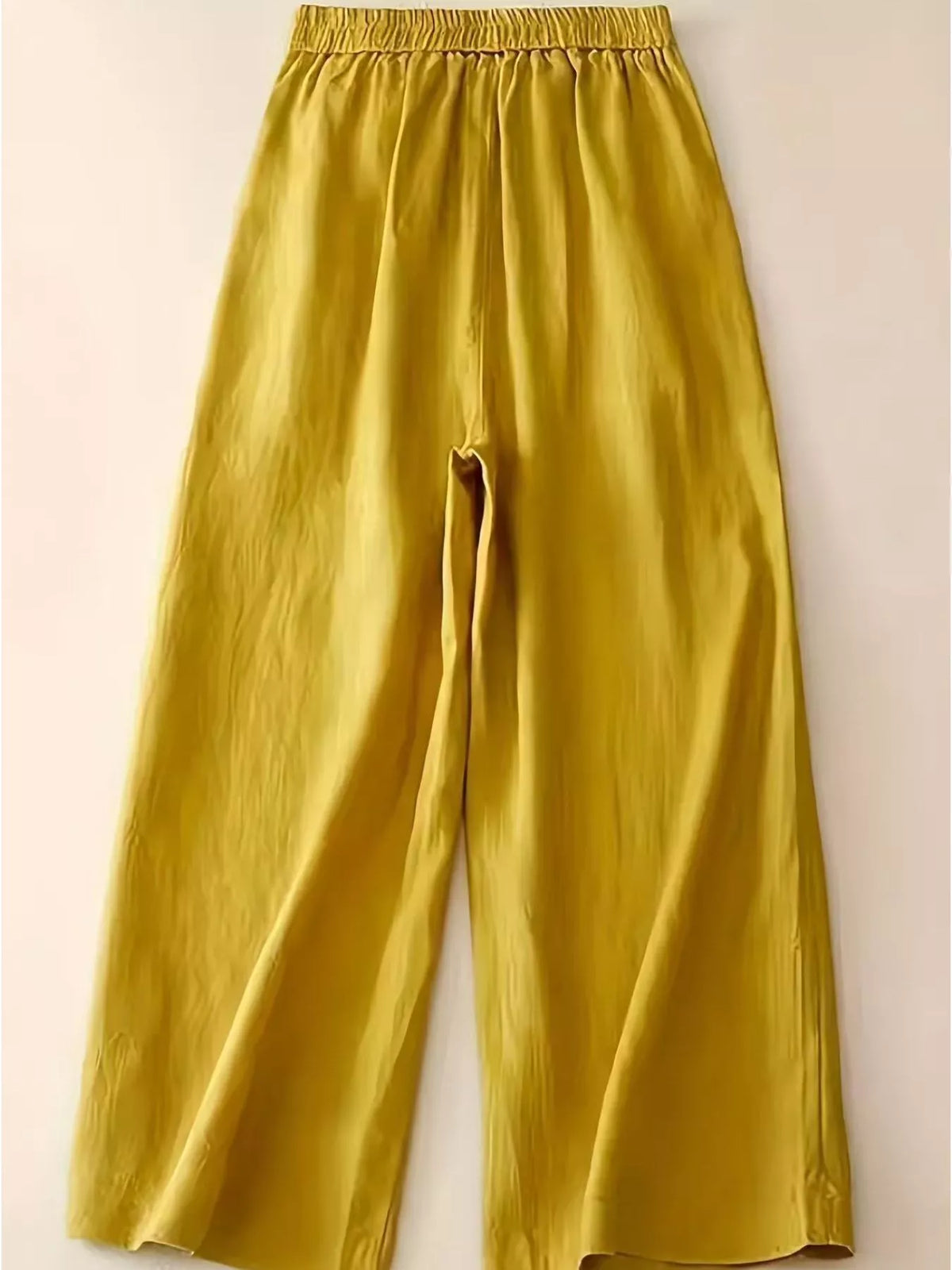 Yellow wide leg cropped pants shown from the side on model