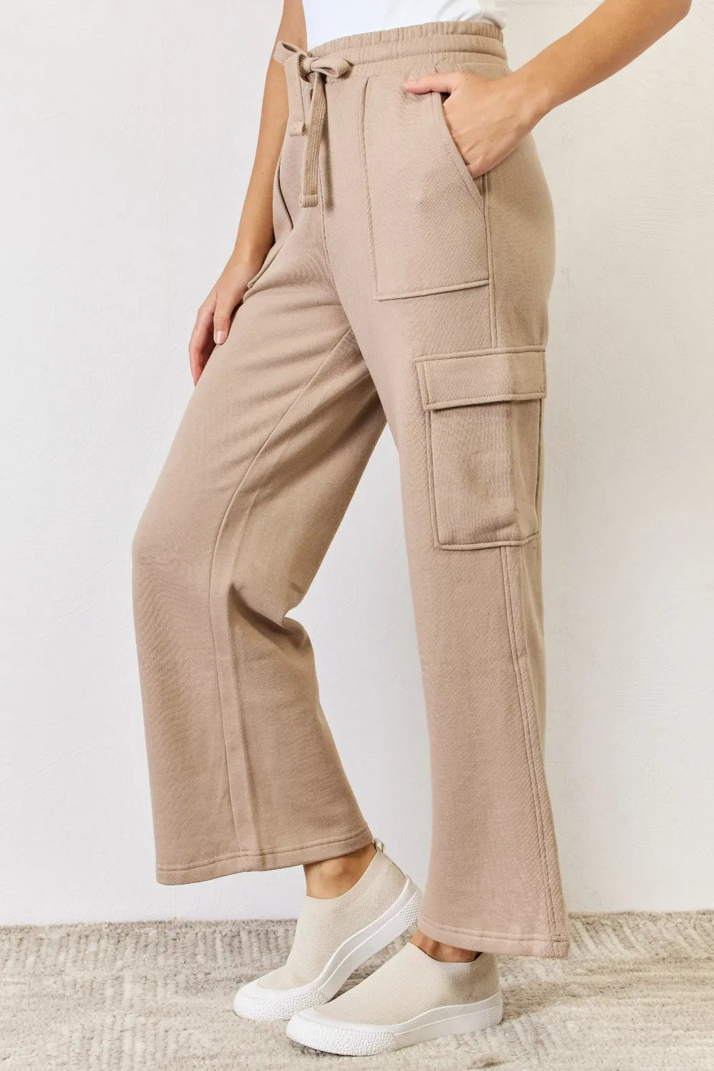 Side cargo pocket detail on tan wide leg pants