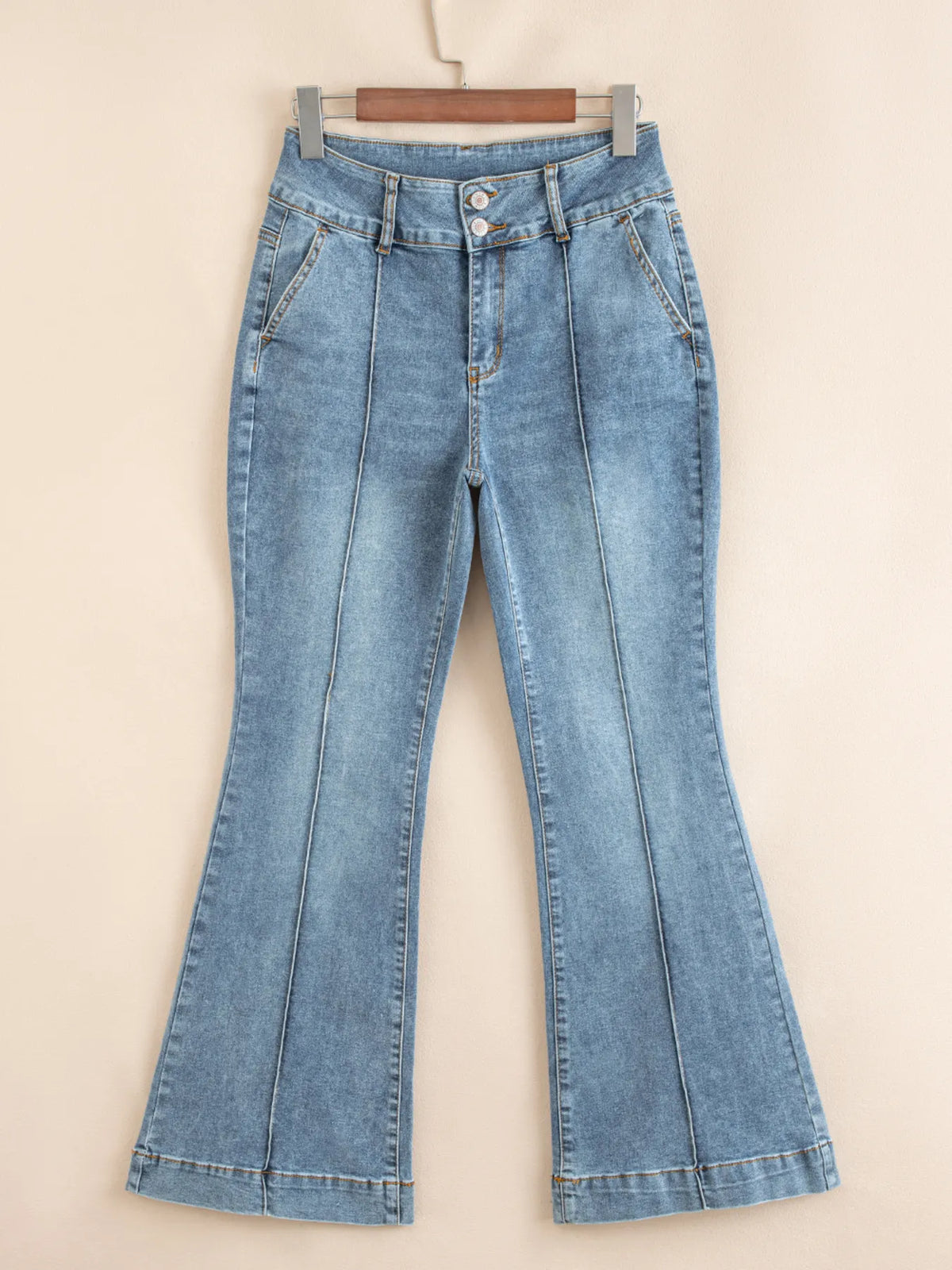 Buttoned pocket detail on medium wash flare jeans
