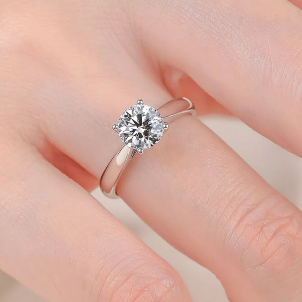 Sterling silver moissanite ring resting on a flat surface