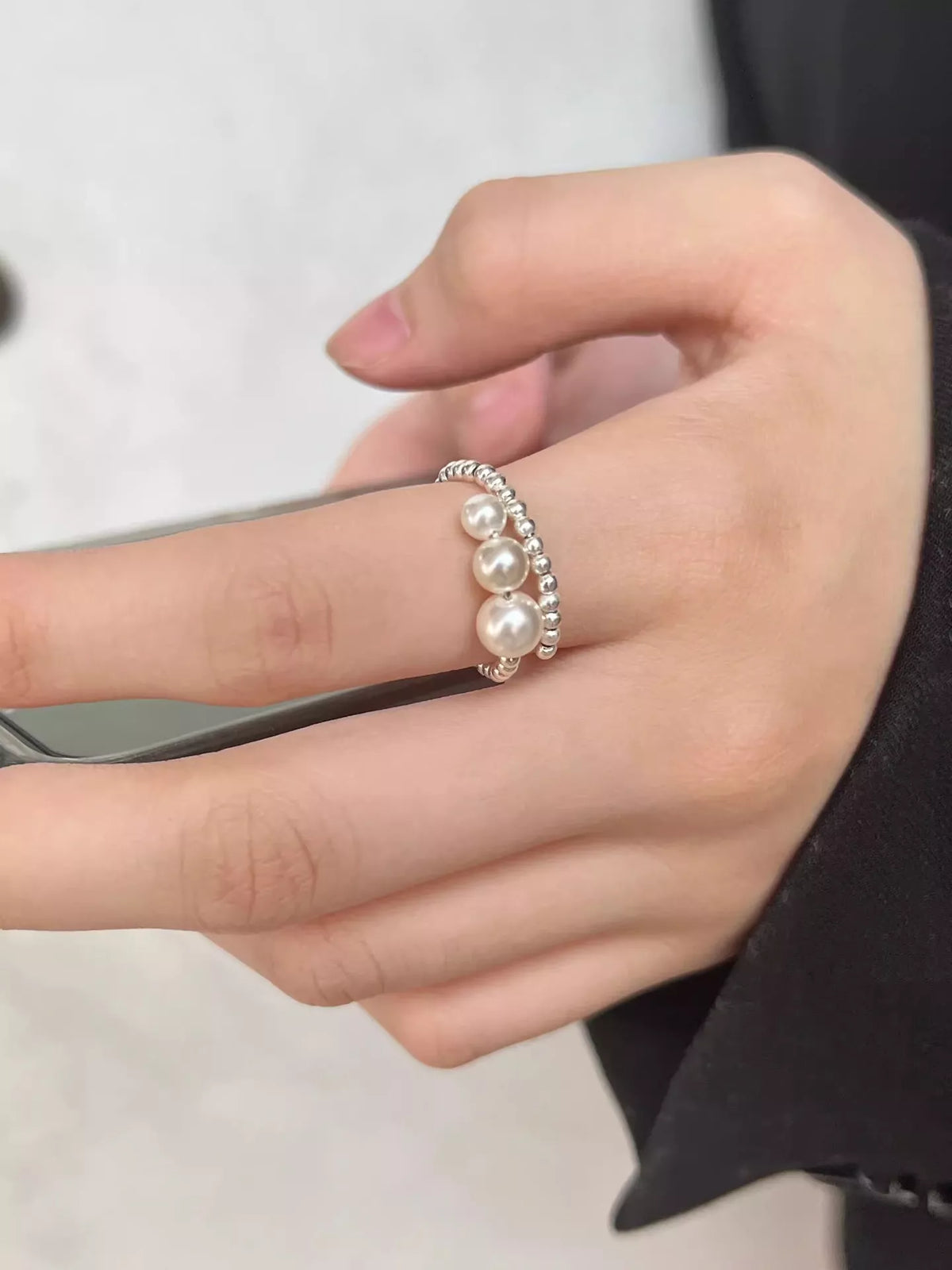 Pearl bypass ring on finger