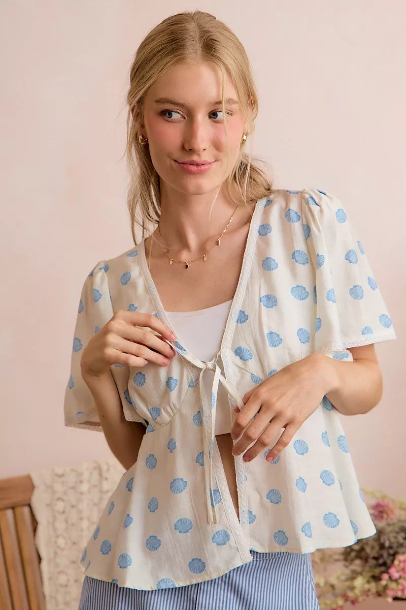 Ivory and blue shell print tie front flutter sleeve blouse side view