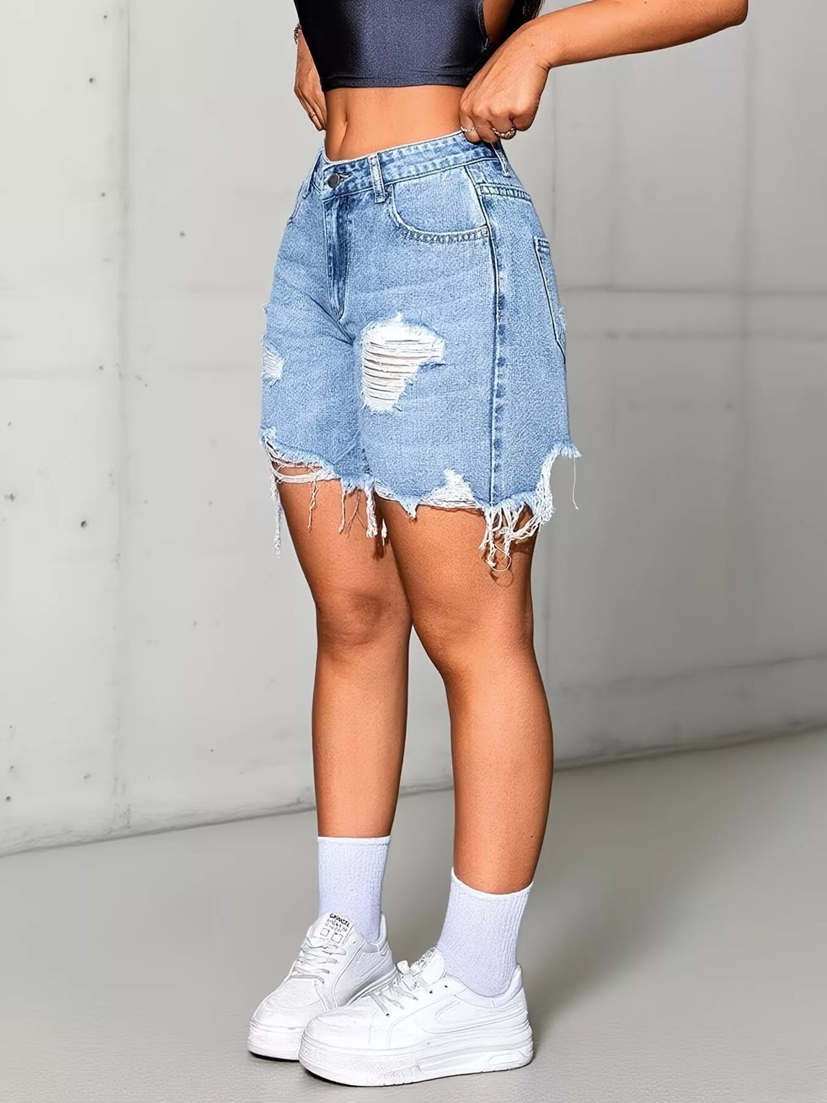 Distressed detailing close up on the light blue shorts